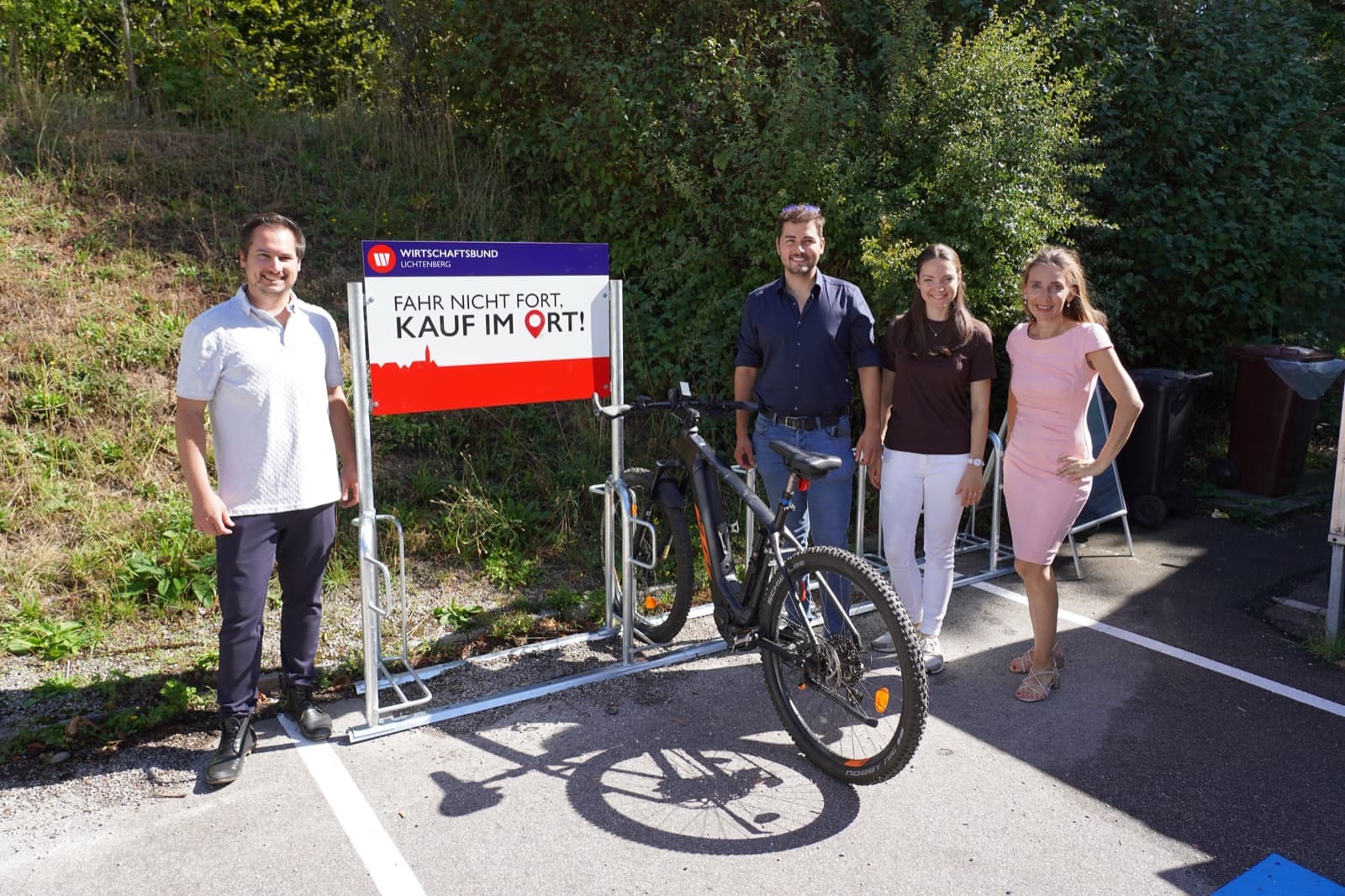 Dominik Sachsenhofer, Michael Wöran, Vera Pischulti und Melanie Wöss beim neuen Fahrradständer mit dem Schild „Fahr nicht fort, kauf im Ort!“ vor dem Nah&Frisch Lichtenberg